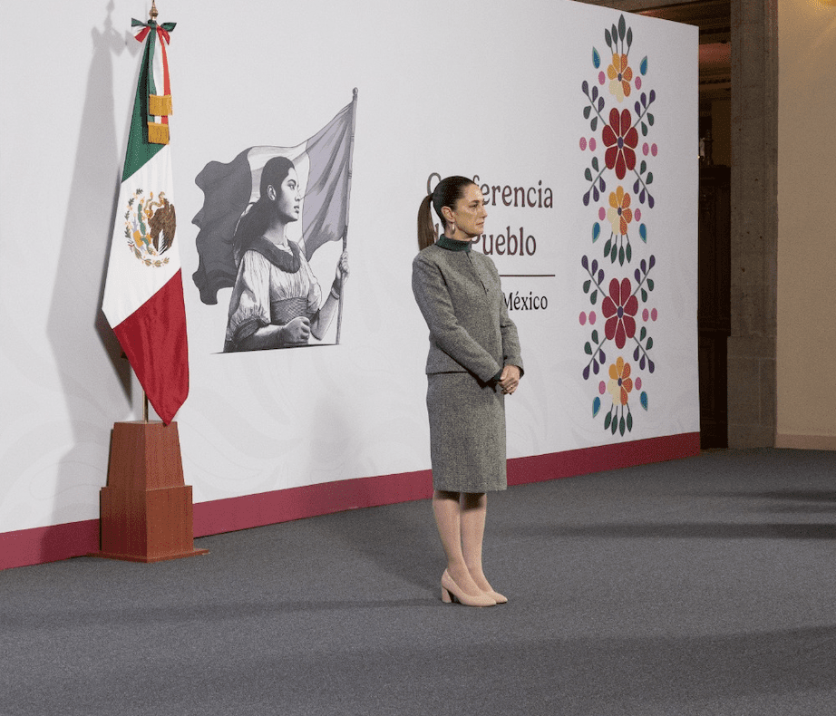 Woman standing near Mexican flag and artwork.